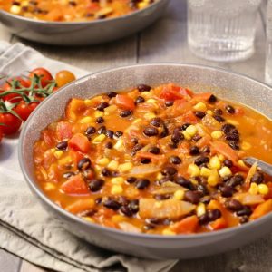 Zuppa fredda estiva con legumi, mais, pomodorini e ortaggi freschi, servita in ciotola rustica. Ricetta antispreco dalla cucina ciociara.