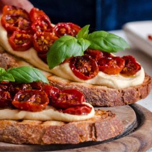 Ricetta del giorno bruschette con crema di ceci, pomodorini arrosto e basilico