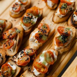 Crostini con stracciatella, alici, scorza di limone e pomodorini confit