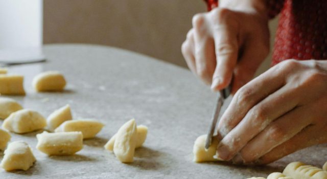 Mani di madre e figlia che impastano gnocchi del 29 su un tavolo di farina, simbolo di tradizione e memoria familiare tra Argentina, Texas e Ciociaria