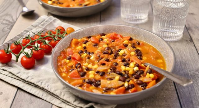Zuppa fredda estiva con legumi, mais, pomodorini e ortaggi freschi, servita in ciotola rustica. Ricetta antispreco dalla cucina ciociara.